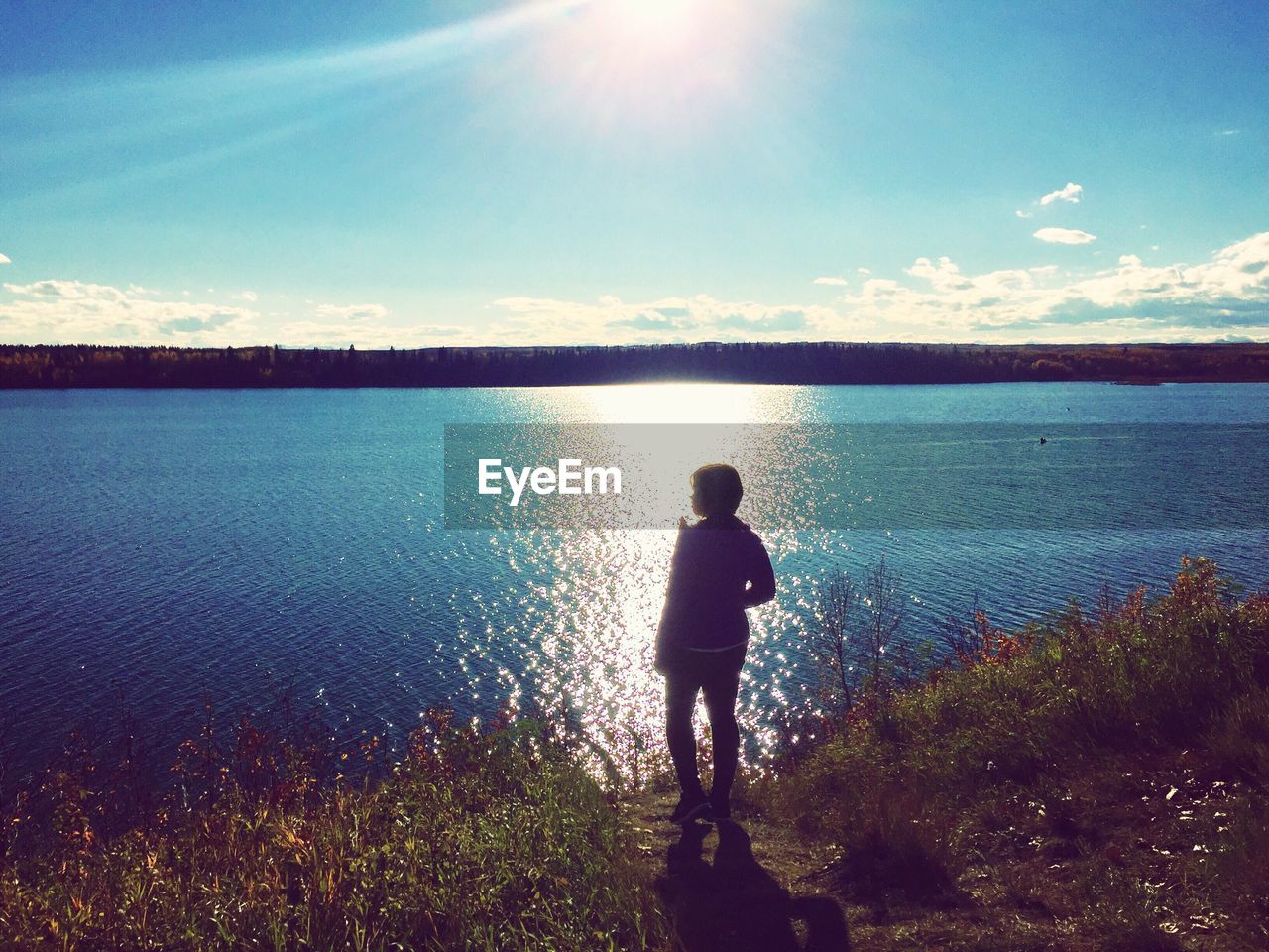 TWO PEOPLE STANDING IN FRONT OF LAKE