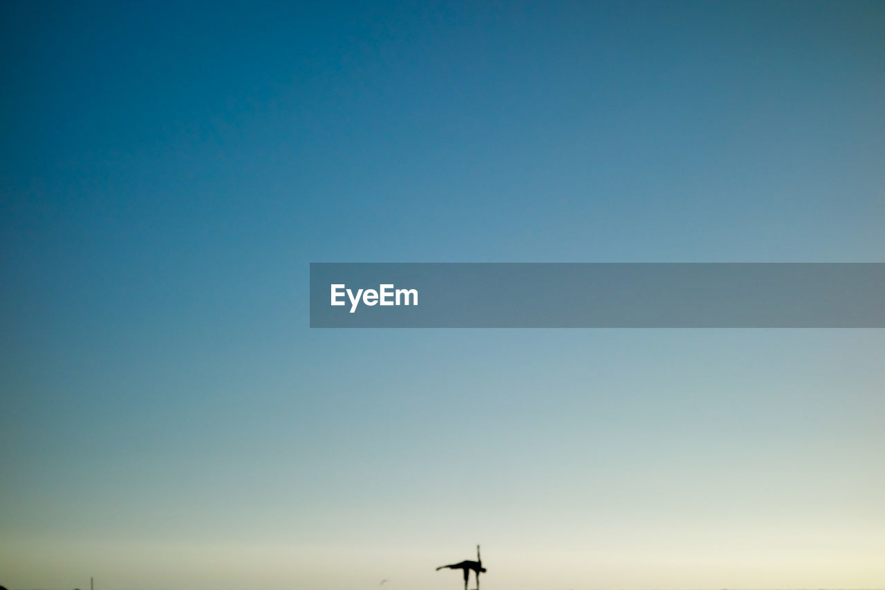 LOW ANGLE VIEW OF HELICOPTER AGAINST CLEAR BLUE SKY