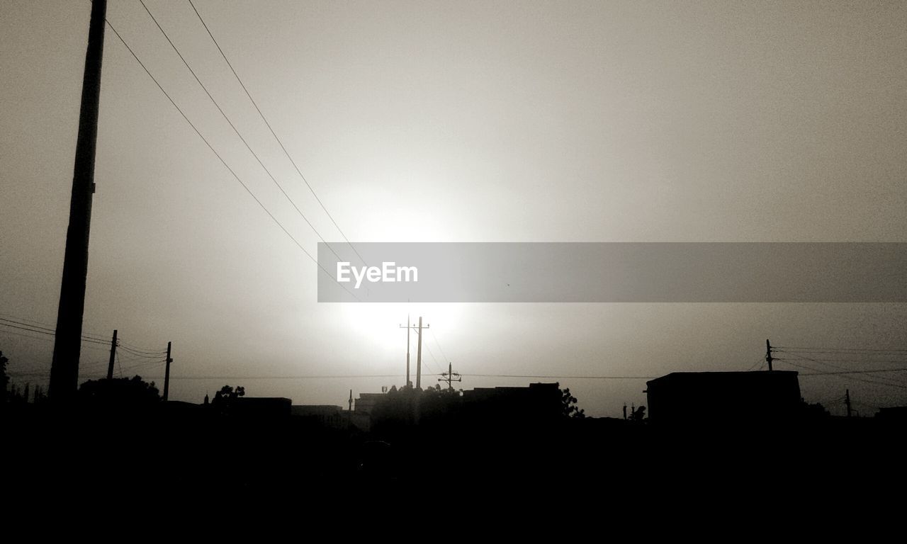 sky, silhouette, cable, architecture, nature, electricity, built structure, darkness, no people, technology, light, cloud, line, building exterior, electricity pylon, horizon, outdoors, morning, city, copy space, power line, black and white, power generation, dusk, low angle view, power supply, beauty in nature, building