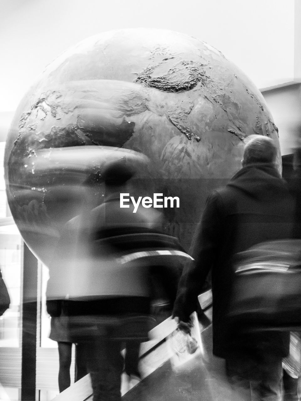 People visiting museum exhibit of planet earth