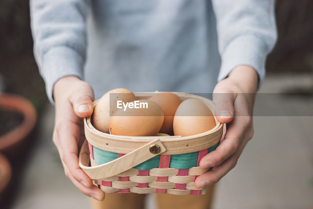 Girl holding a basket of fresh eggs, happy easter