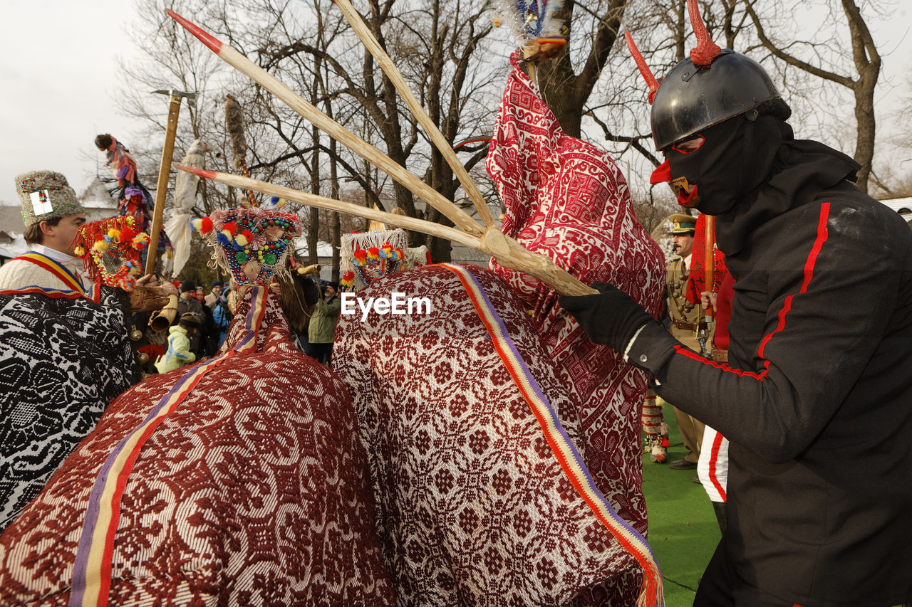 Person in costume holding stick by decoration during event