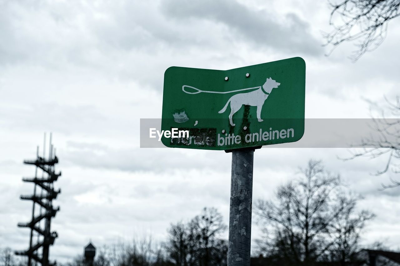 Close-up of road sign against sky