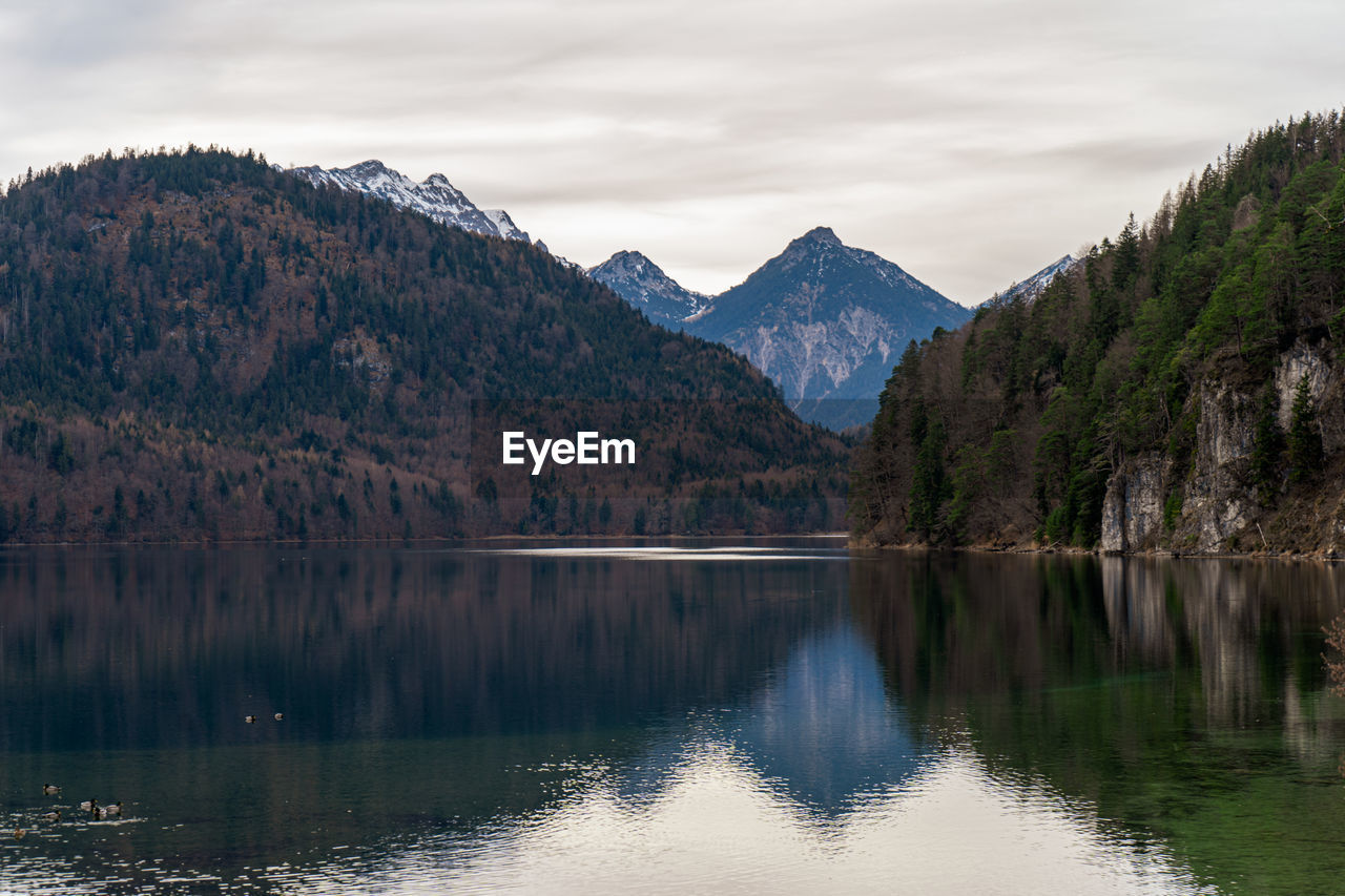 scenic view of lake by mountain against sky