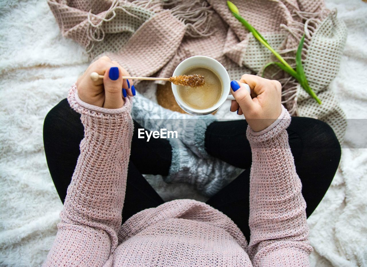 LOW SECTION VIEW OF WOMAN DRINKING COFFEE CUP