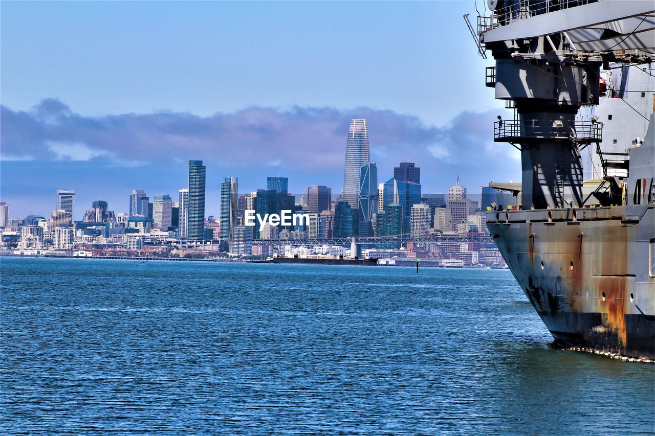 SEA BY BUILDINGS AGAINST SKY IN CITY