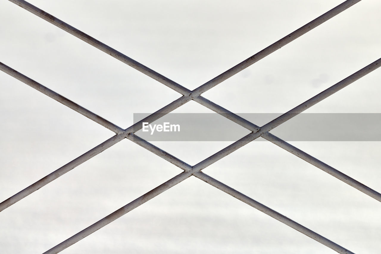 Metal fence with rhombus ornament on grey background, close up. sectional view of metal fence part