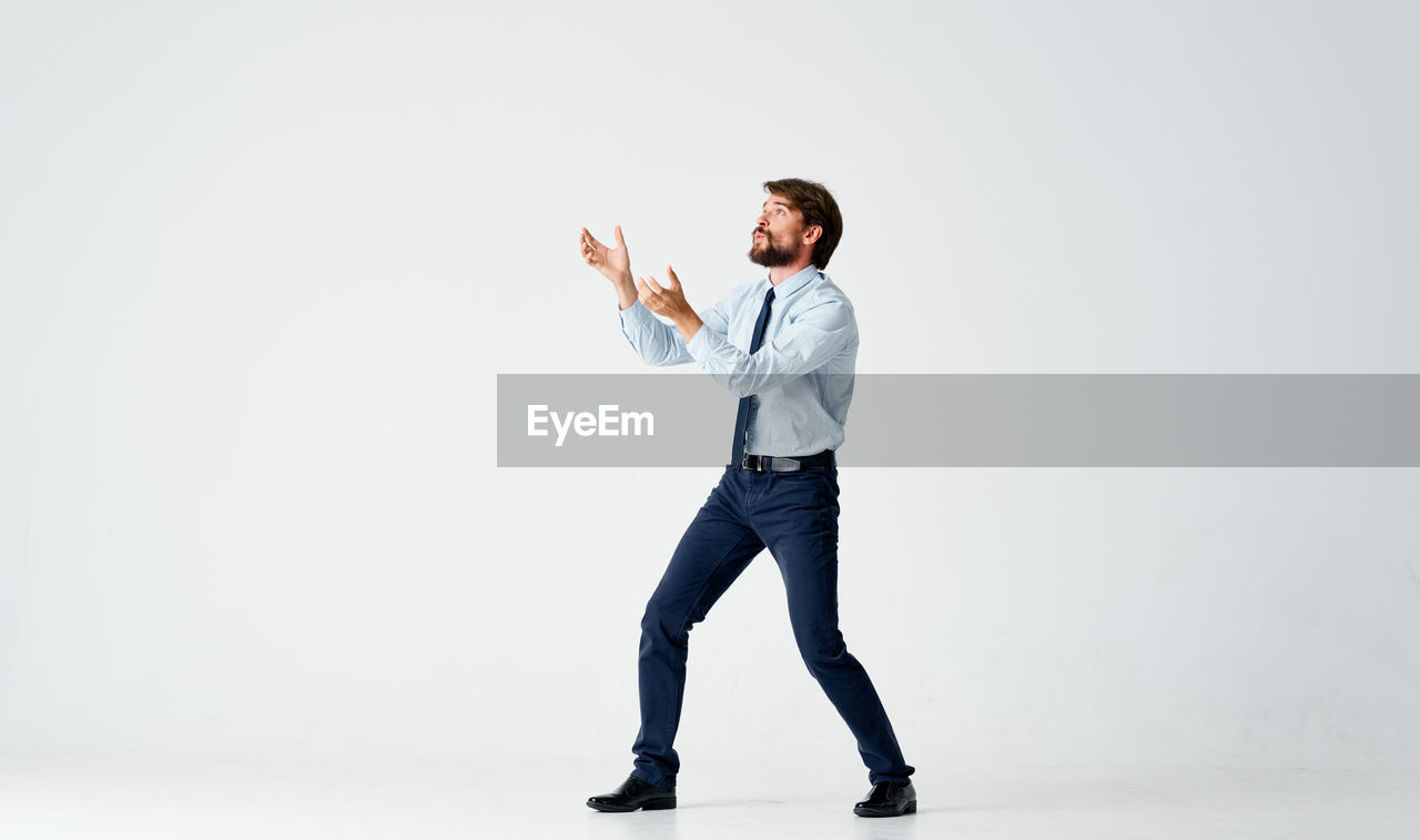 Full length of man standing against white background