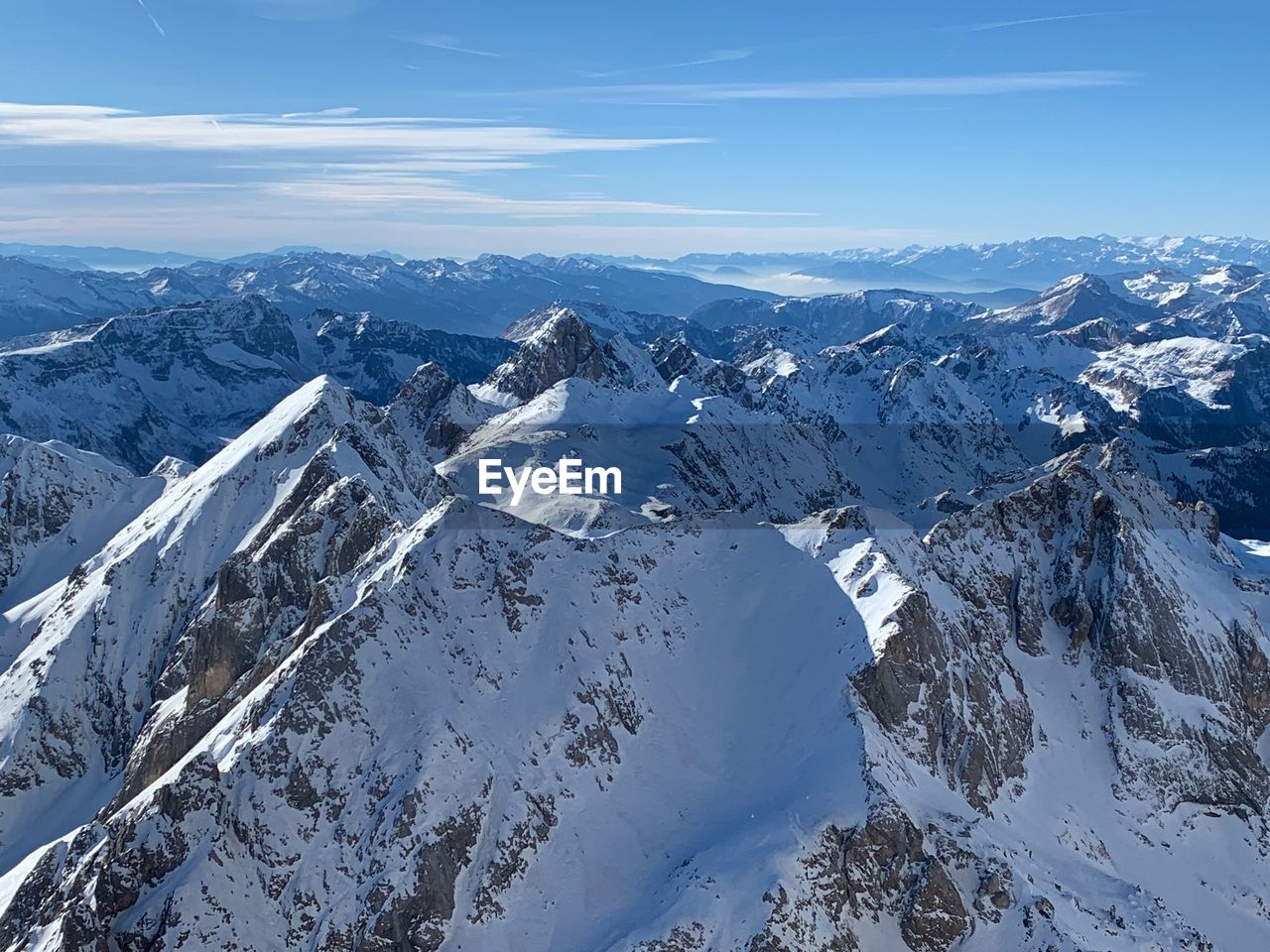 Aerial view of snow covered mountains against sky