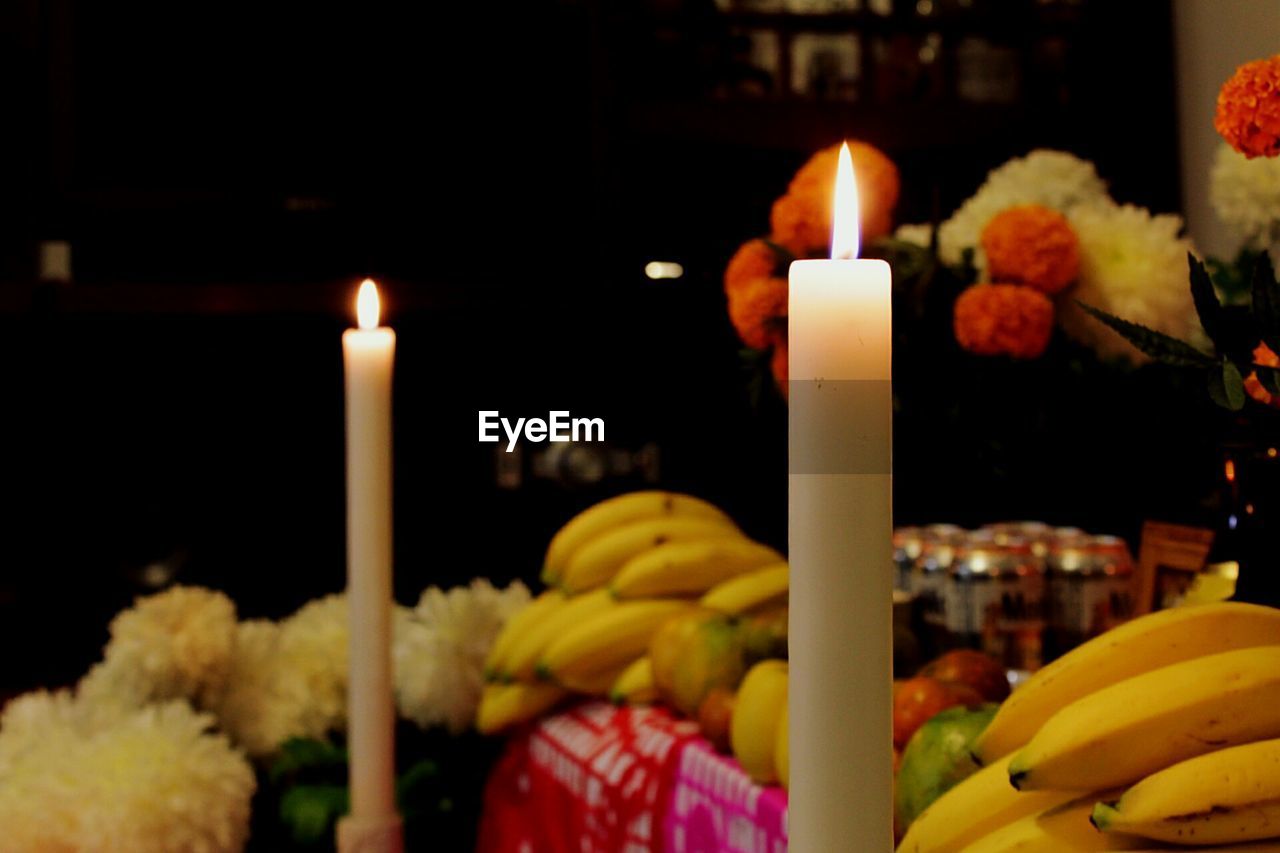 CLOSE-UP OF LIT CANDLES ON BIRTHDAY CAKE