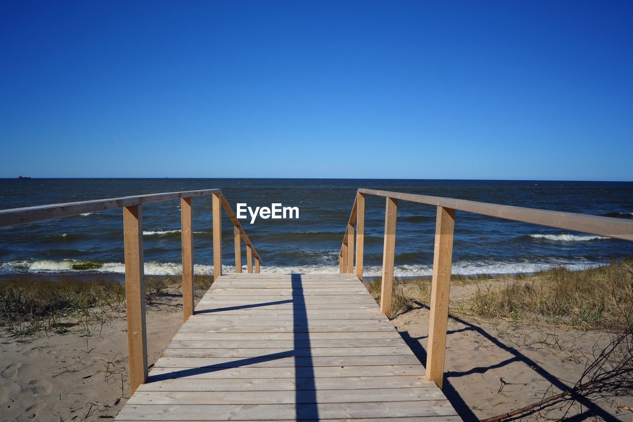 Scenic view of beach against clear blue sky