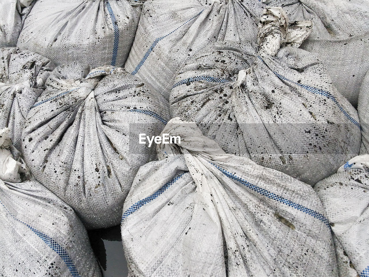 Full frame shot of dirty white sacks at commercial dock