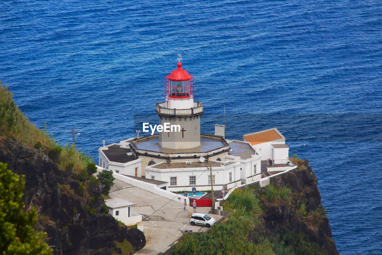 High angle view of lighthouse on building by sea