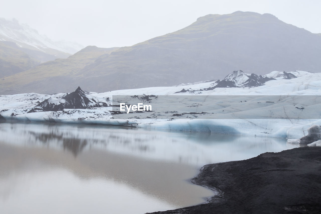 Beautiful silent landscape of glacier sólheimajökull with tranquil water and misty air, iceland.