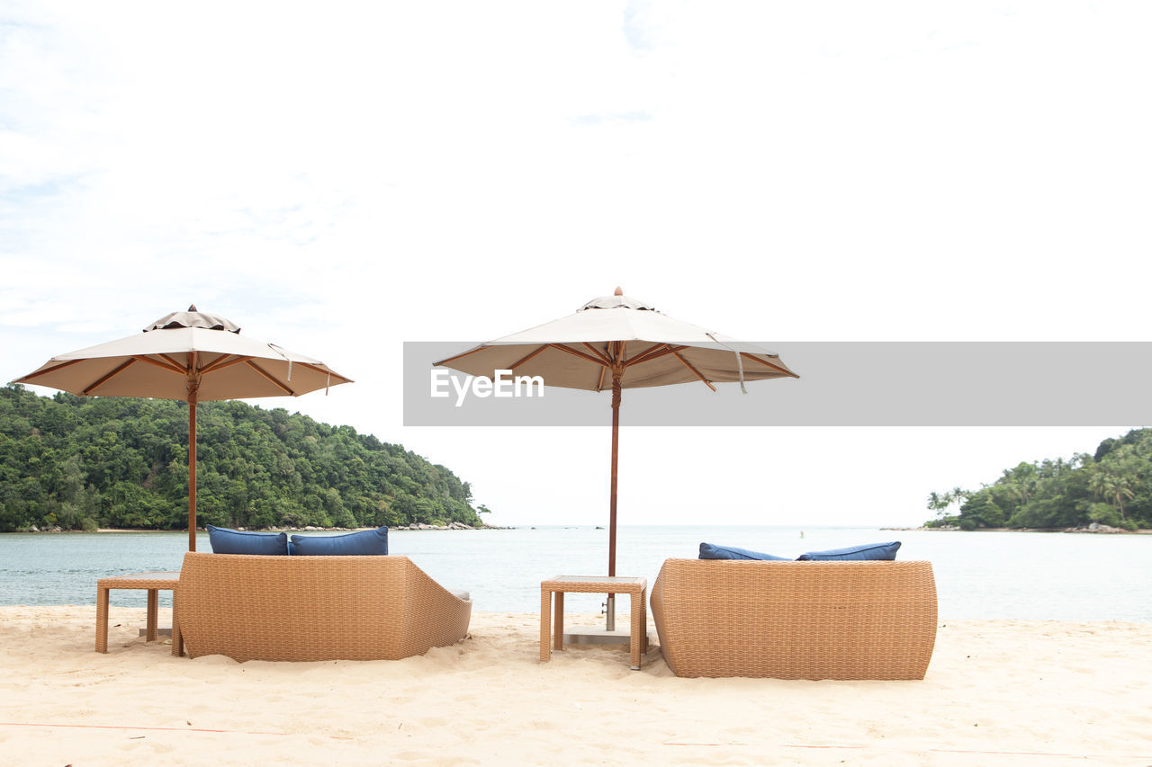 CHAIRS ON BEACH AGAINST SKY