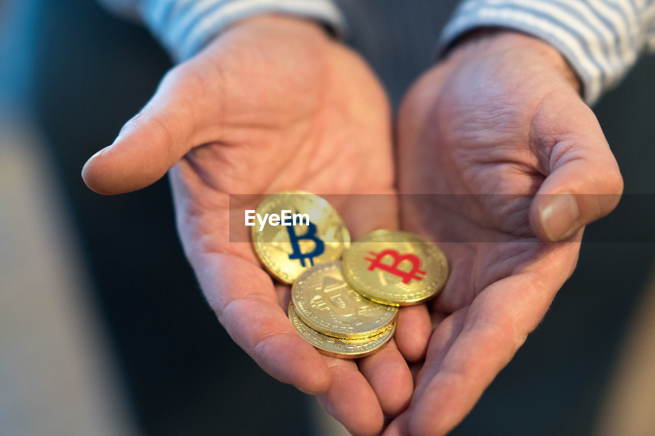 Close-up of person holding bitcoins