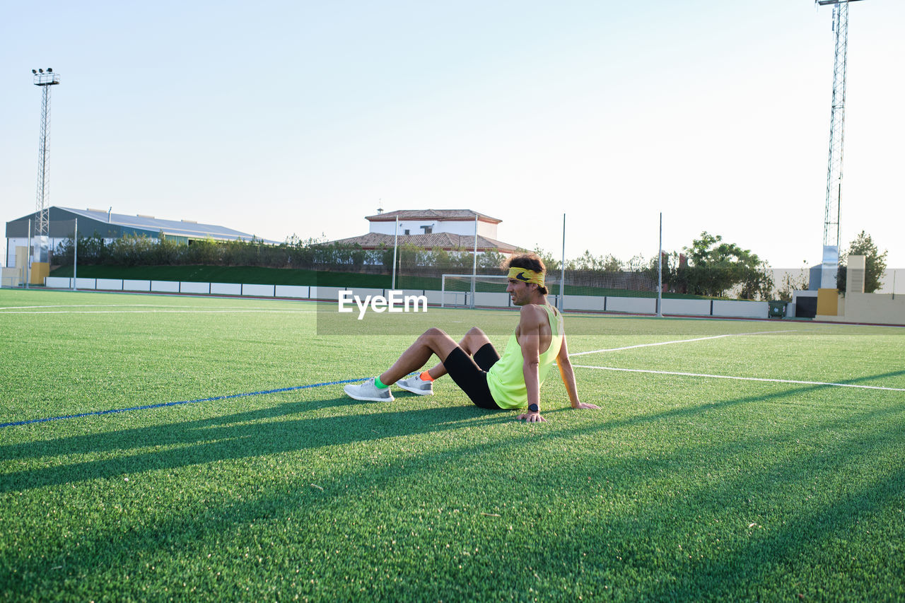 Young man resting on grass after training
