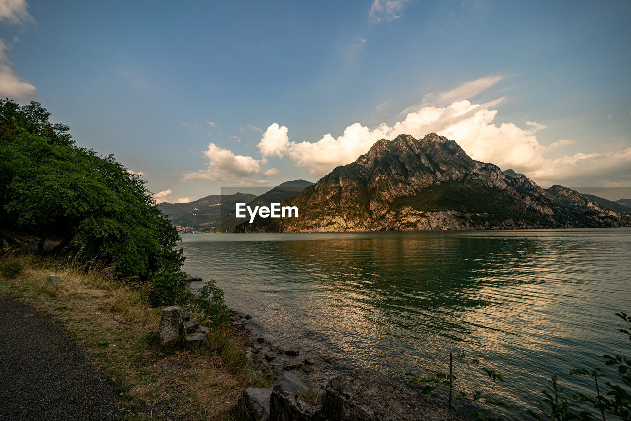 Scenic view of lake by mountains against sky