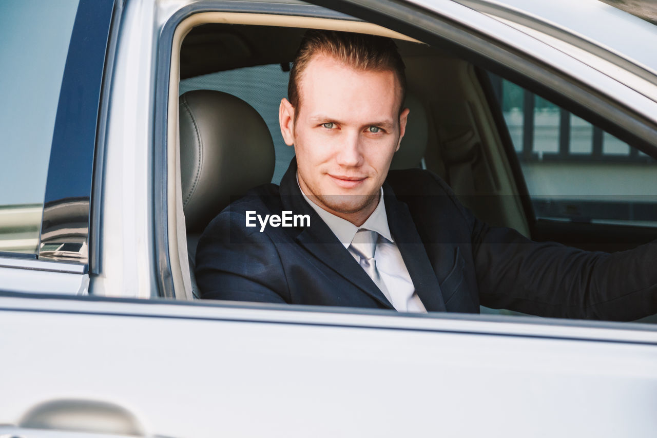 Portrait of businessman driving car