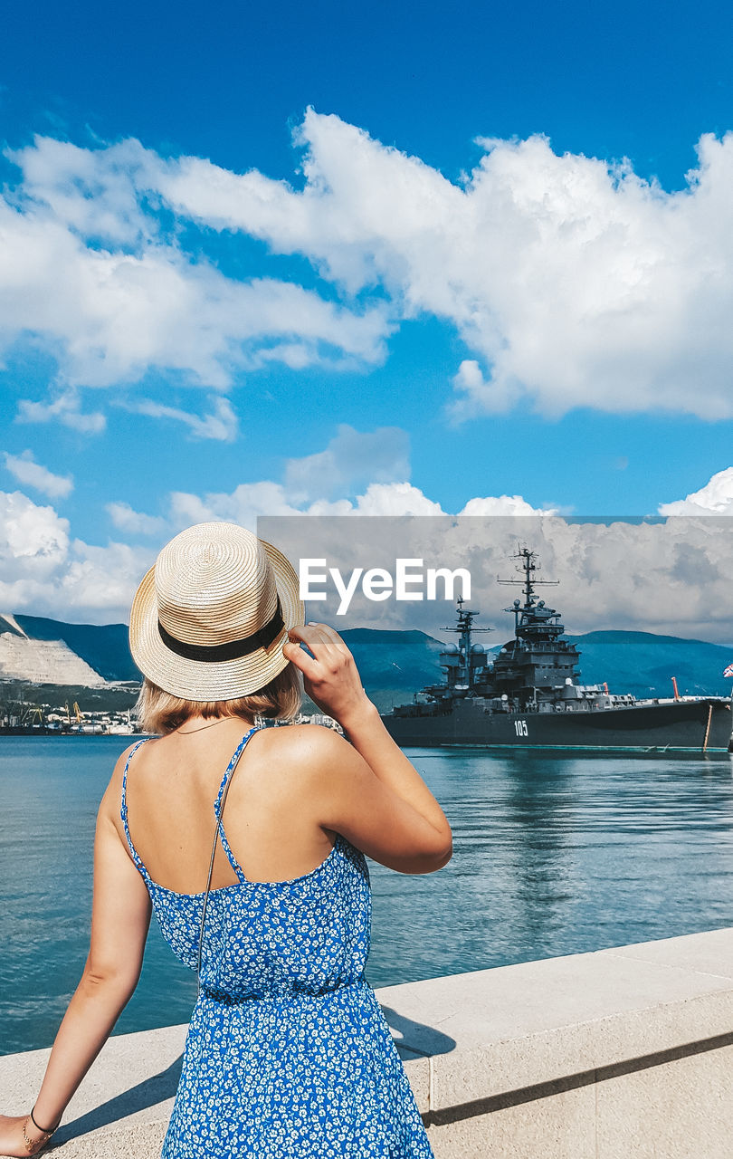 Rear view of woman looking at sea against sky