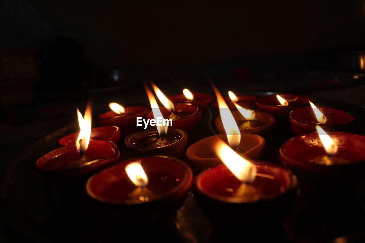 Bunch of oil diyas with dark background in a plate