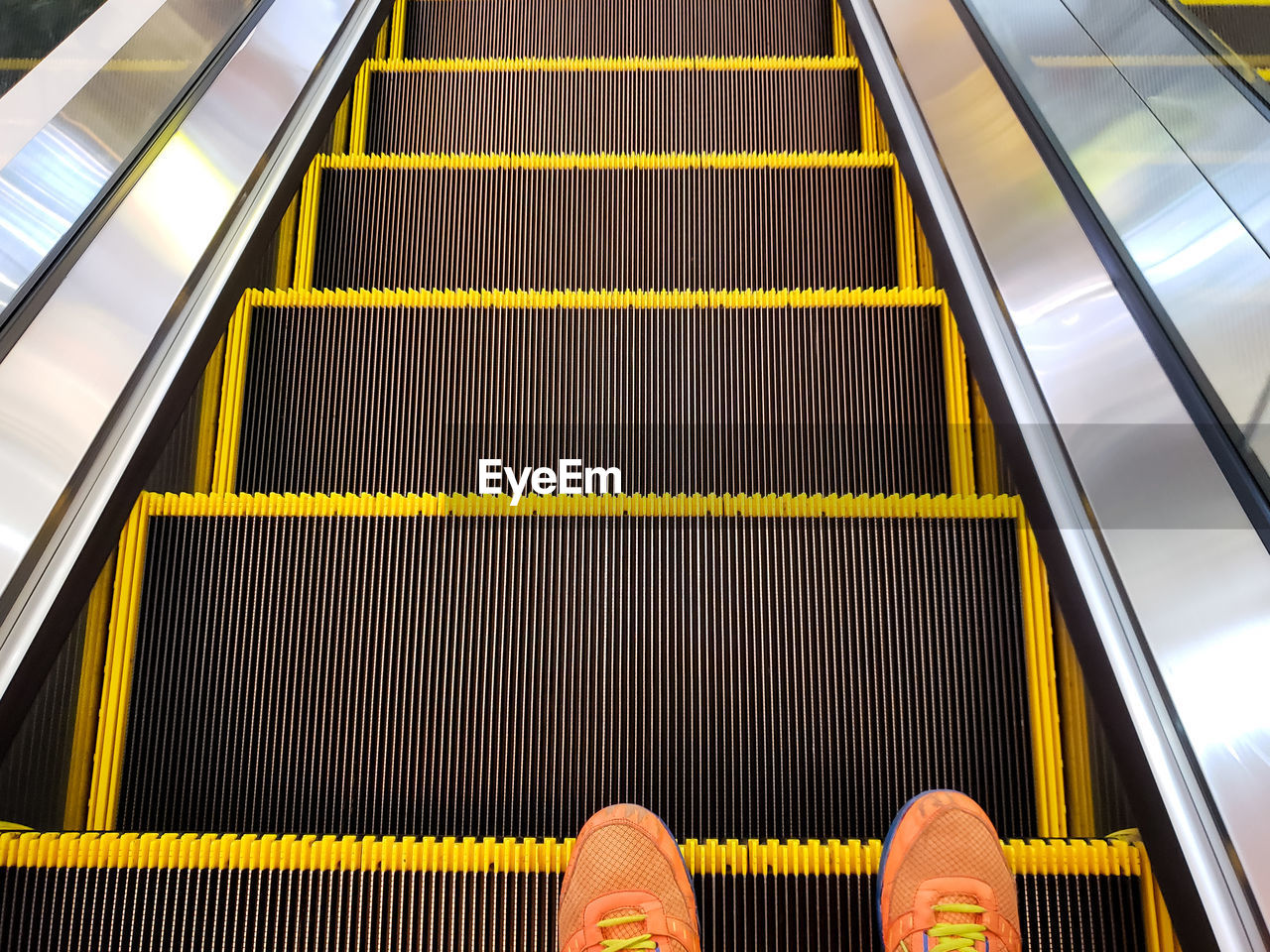 LOW SECTION OF PERSON ON ESCALATOR IN OFFICE