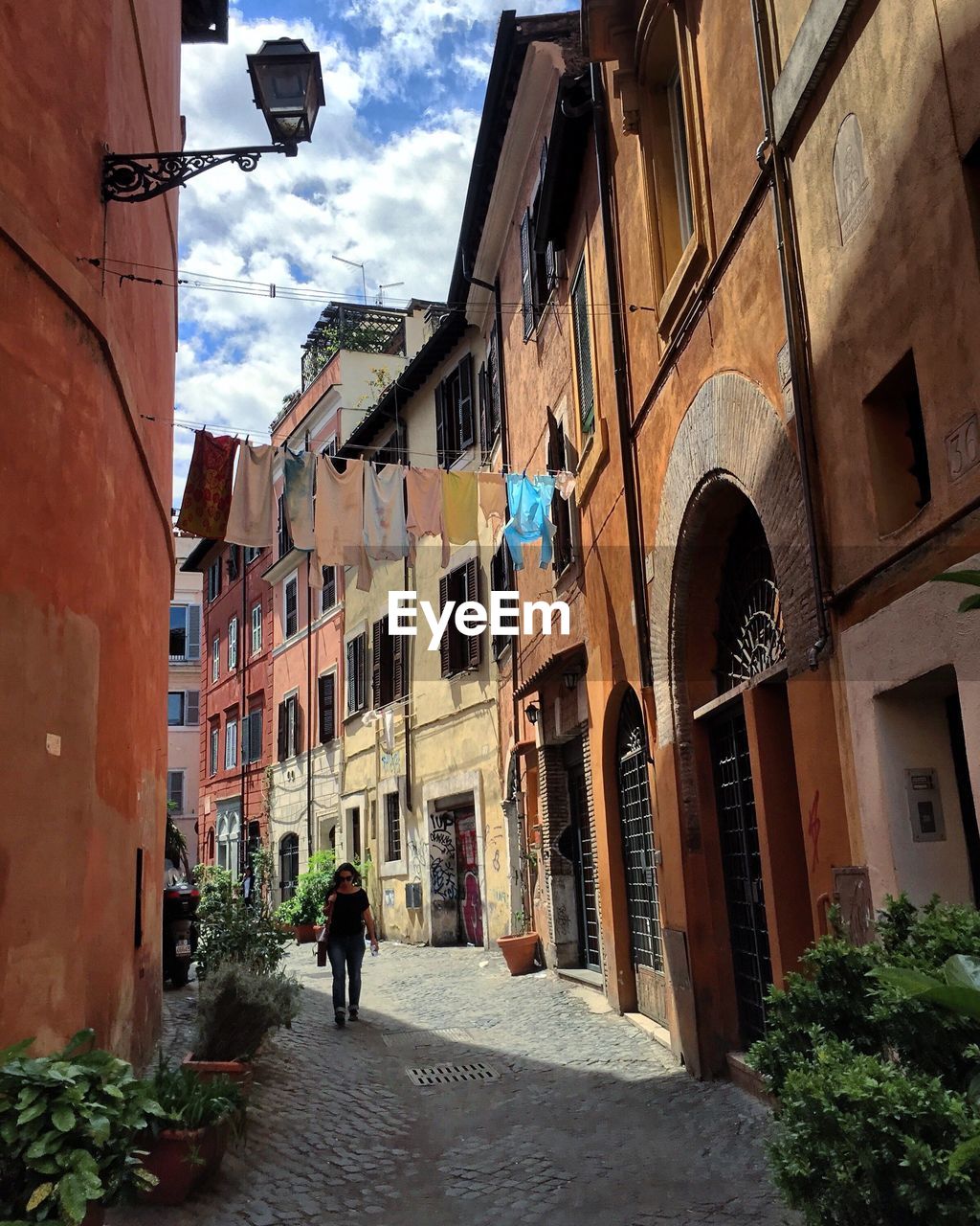 REAR VIEW OF WOMAN WALKING IN CITY