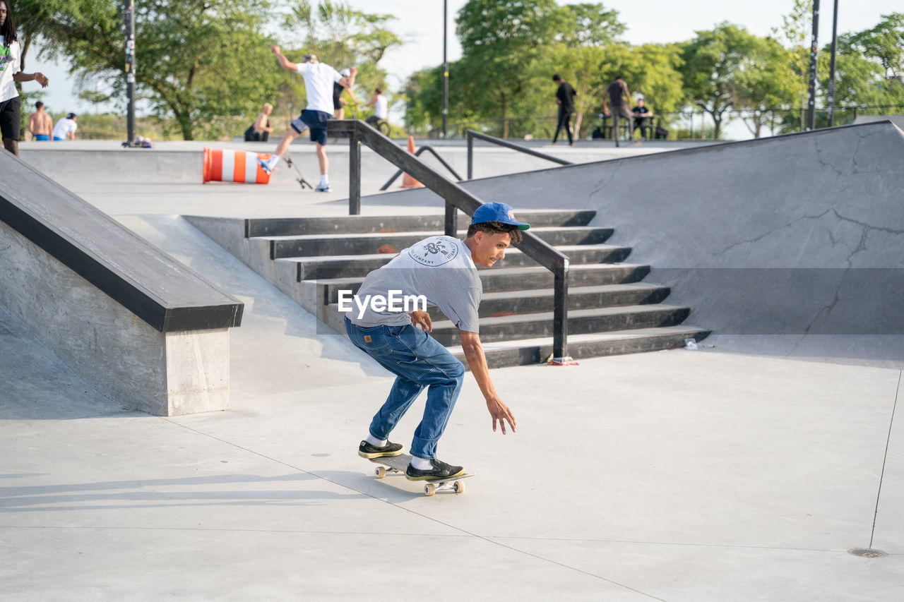 FULL LENGTH OF A MAN SKATEBOARDING ON SKATEBOARD