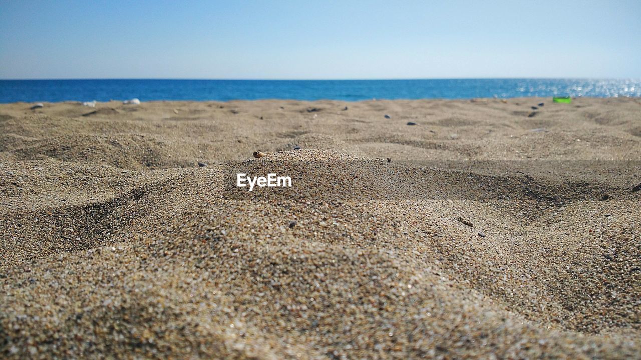 Scenic view of sandy beach against clear sky