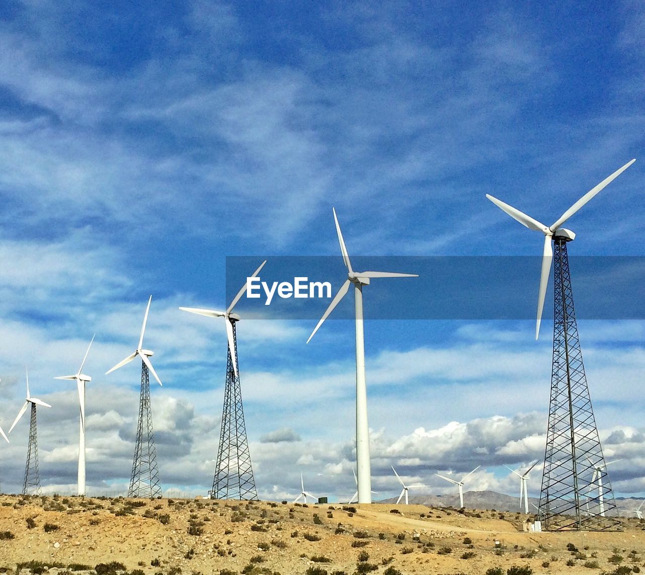 Windmills on landscape against sky