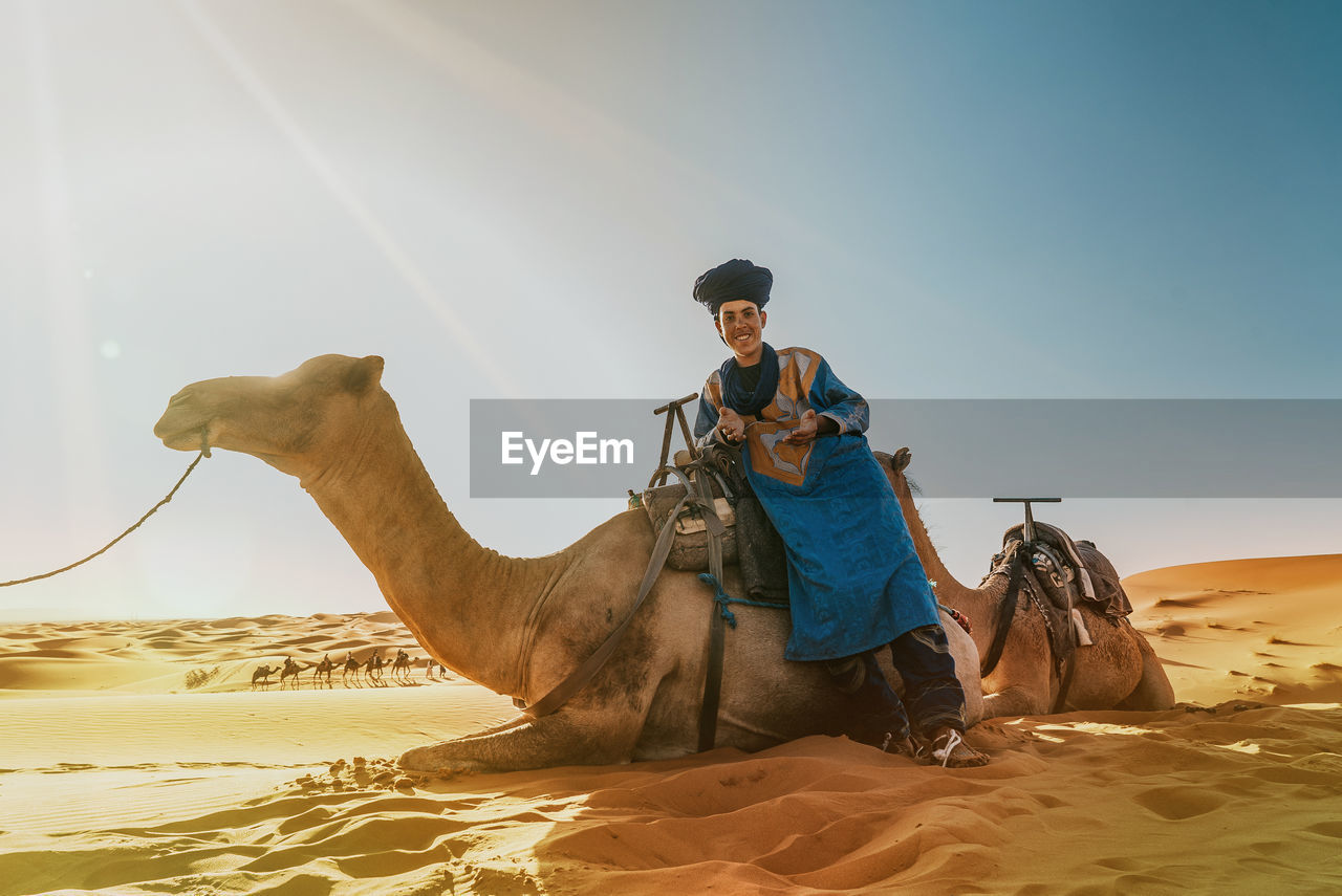 MAN RIDING HORSE IN DESERT