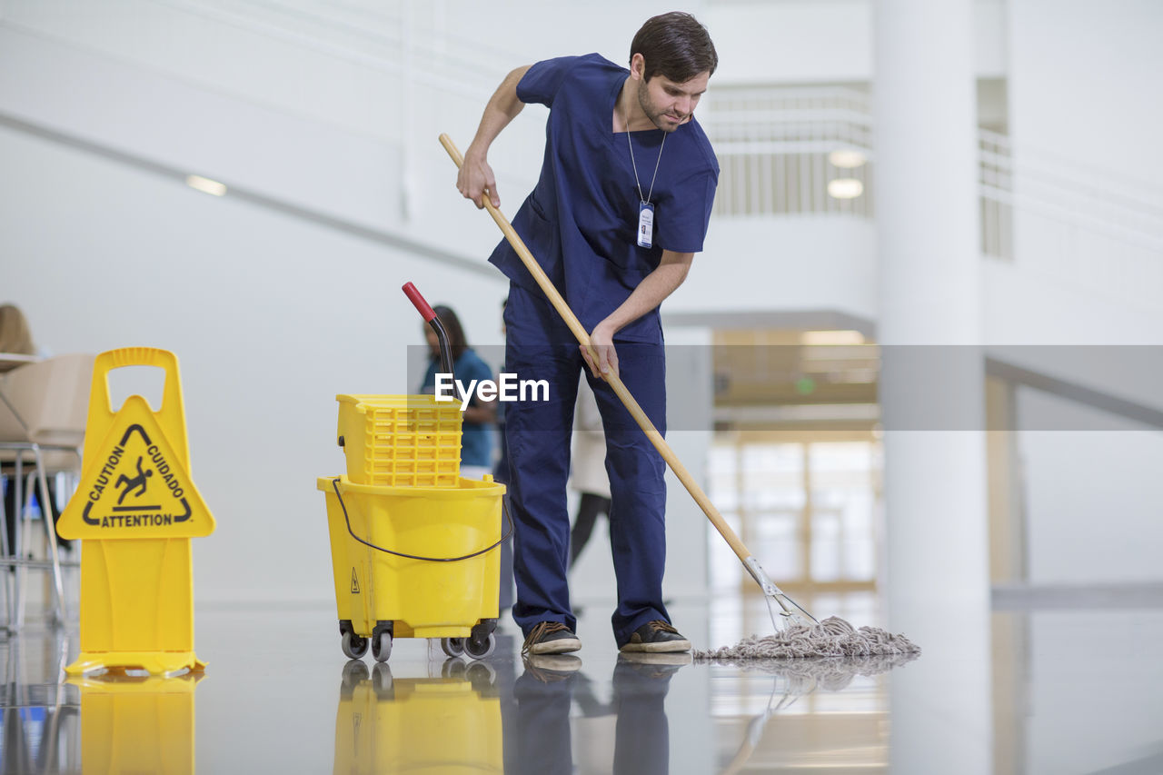 Male worker cleaning hospital floor