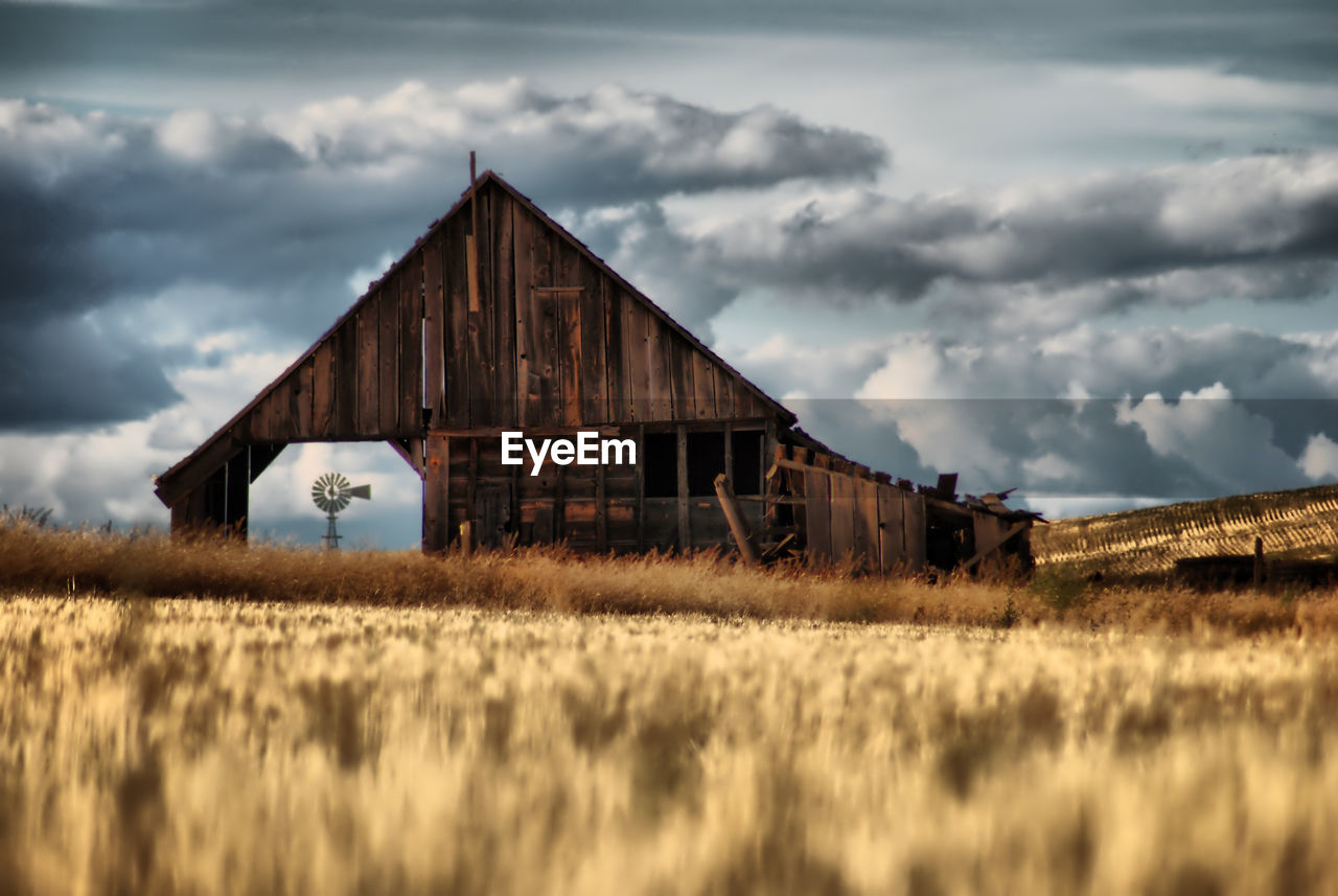 Abandoned barn on field against sky