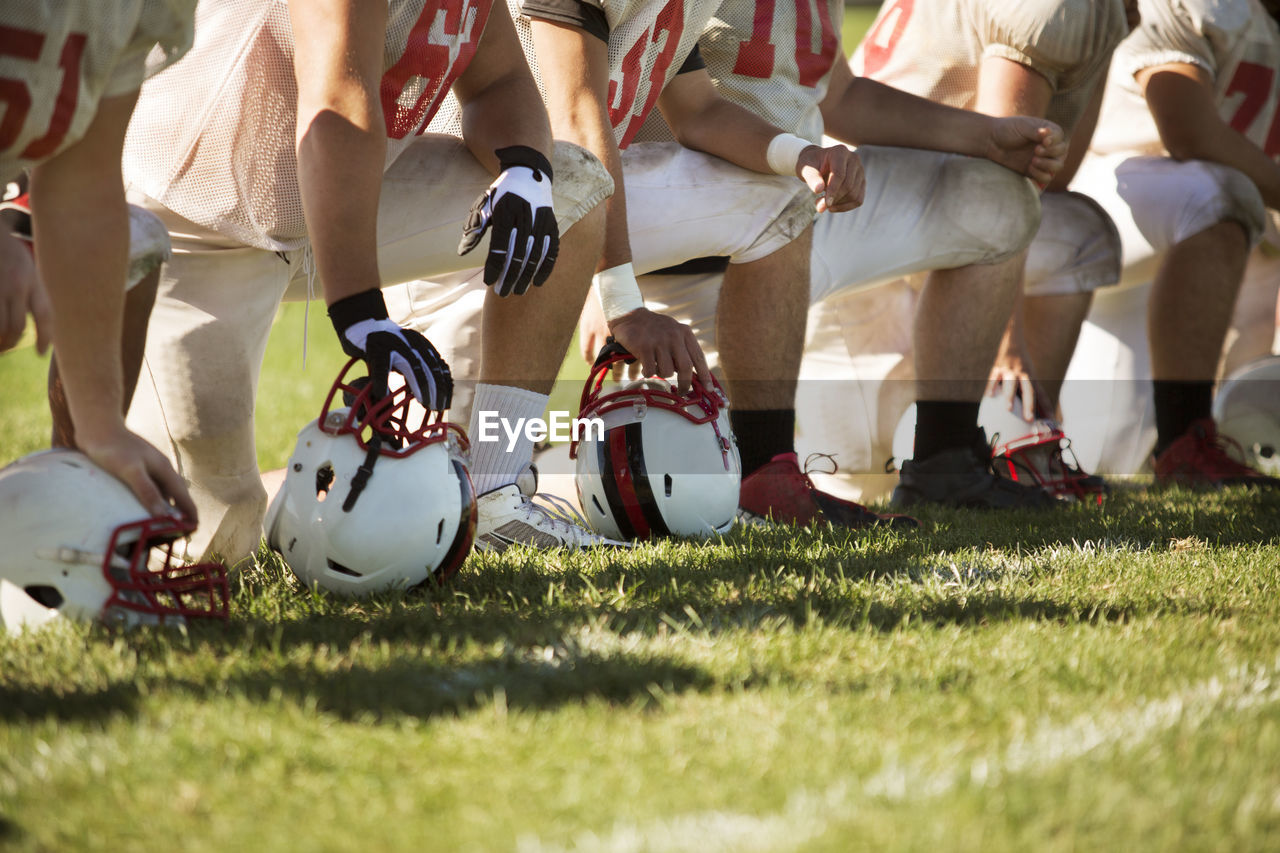 Low section of football team kneeling on playing field
