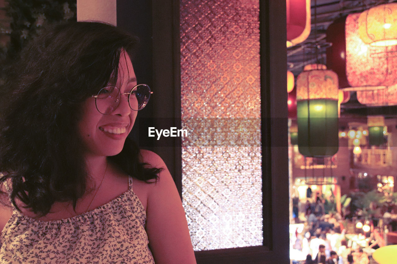 Smiling asian woman with eye glasses against the hanging chinese lanterns