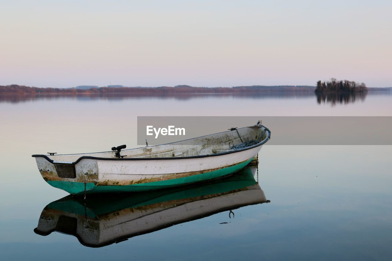 Boat moored in lake against clear sky