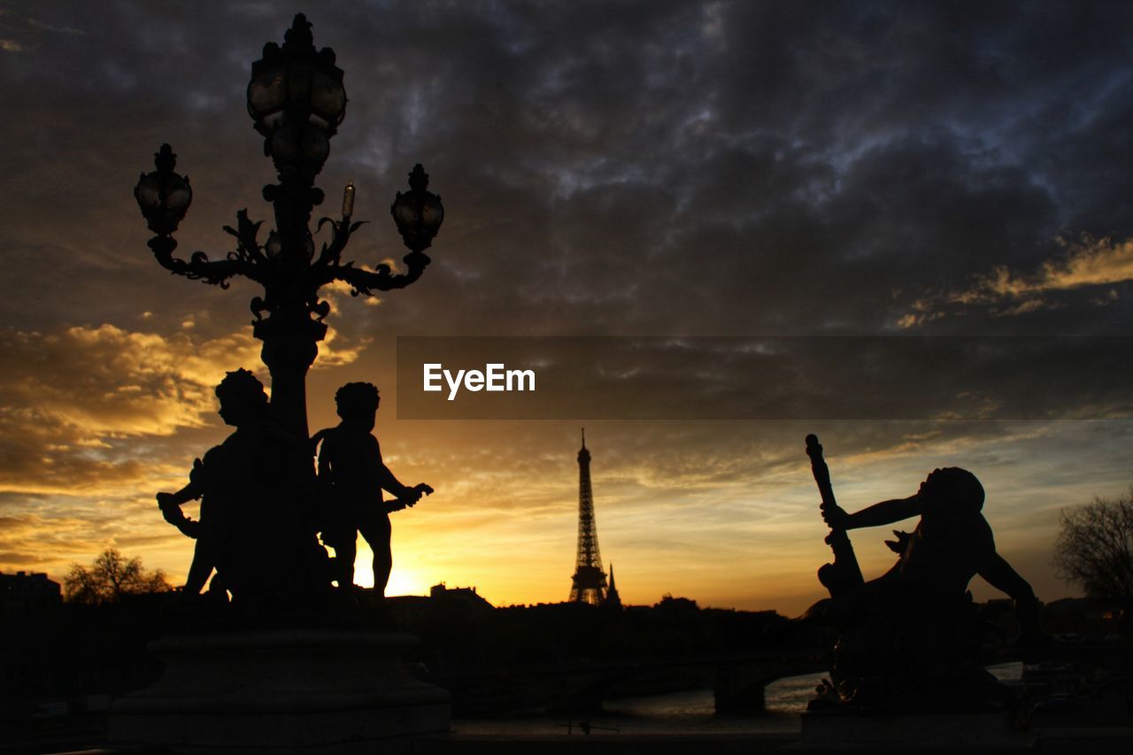 Silhouette statue against sky during sunset