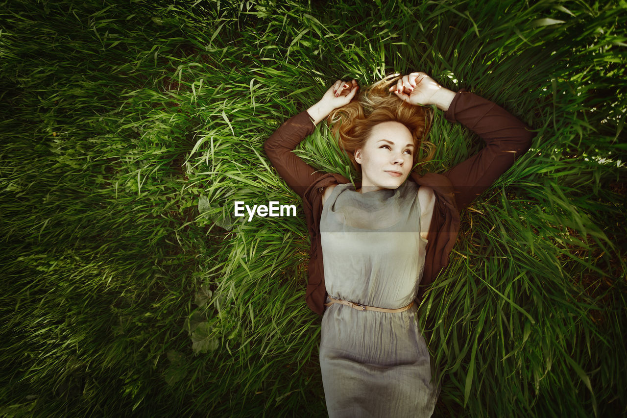 High angle view of smiling woman lying on grass