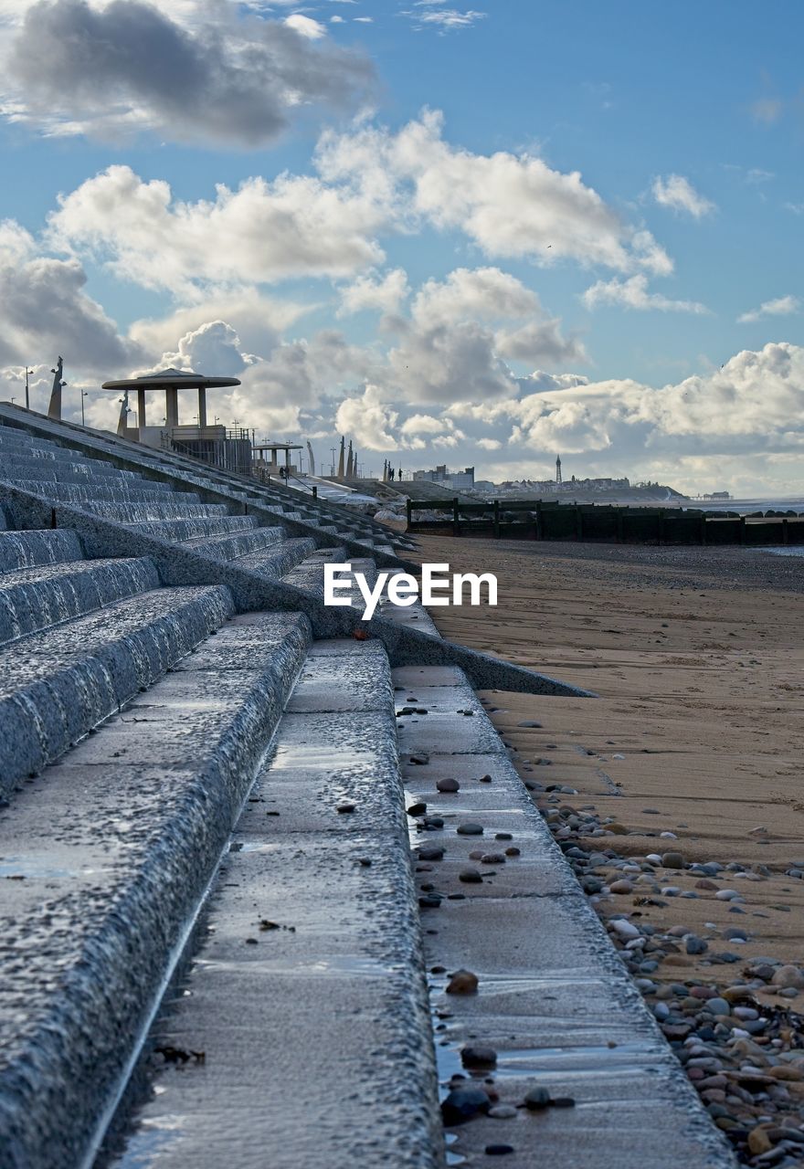 Scenic view of steps and beach against sky