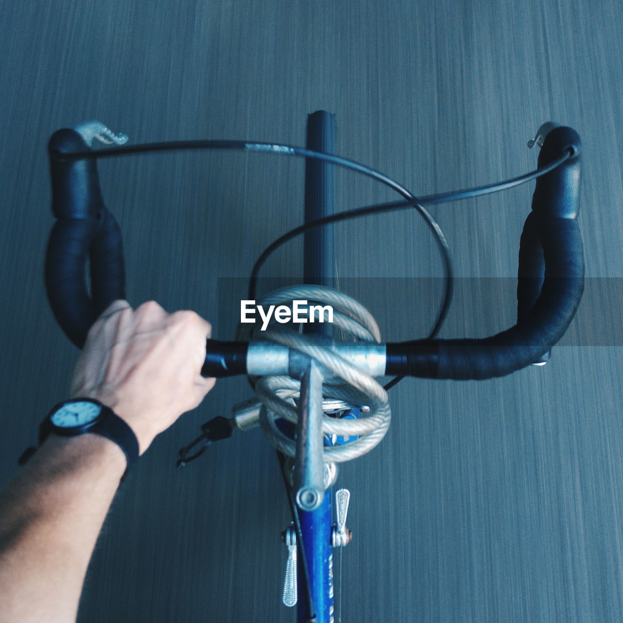 Cropped image of man holding handle while riding bicycle