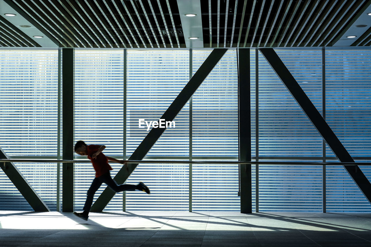 Side view of boy running in corridor