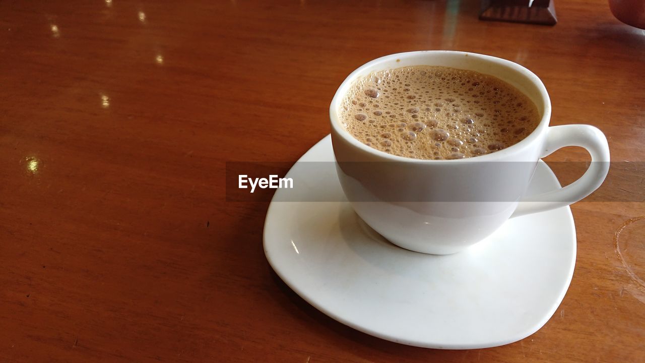 CLOSE-UP OF COFFEE CUP ON TABLE