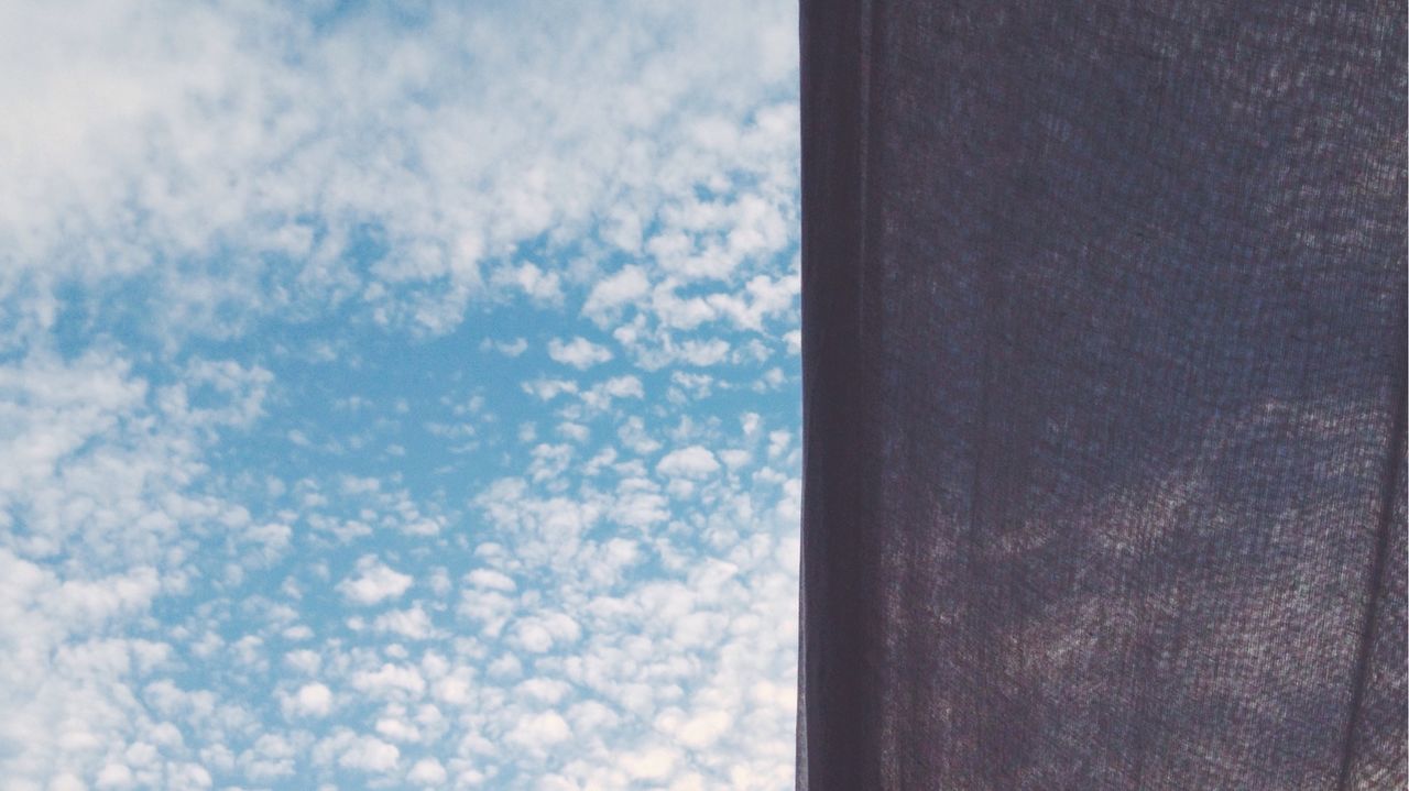 Low angle view of canvas against cloudy sky