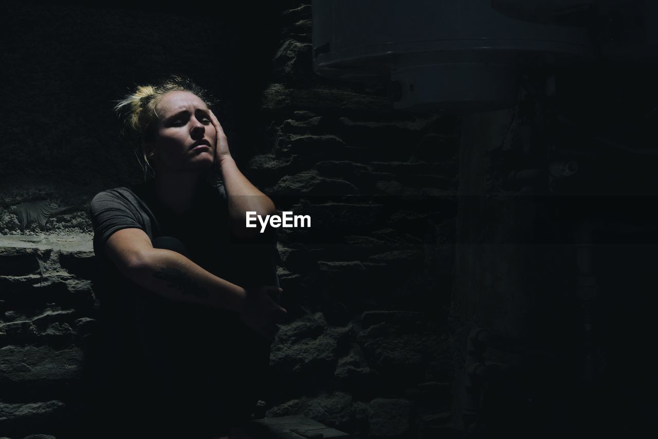 Portrait of depressed woman in basement