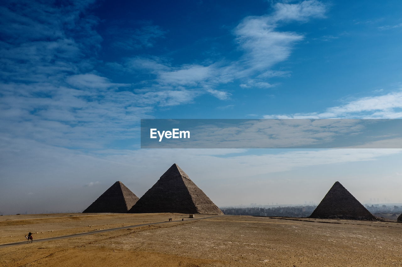 Pyramids against cloudy blue sky
