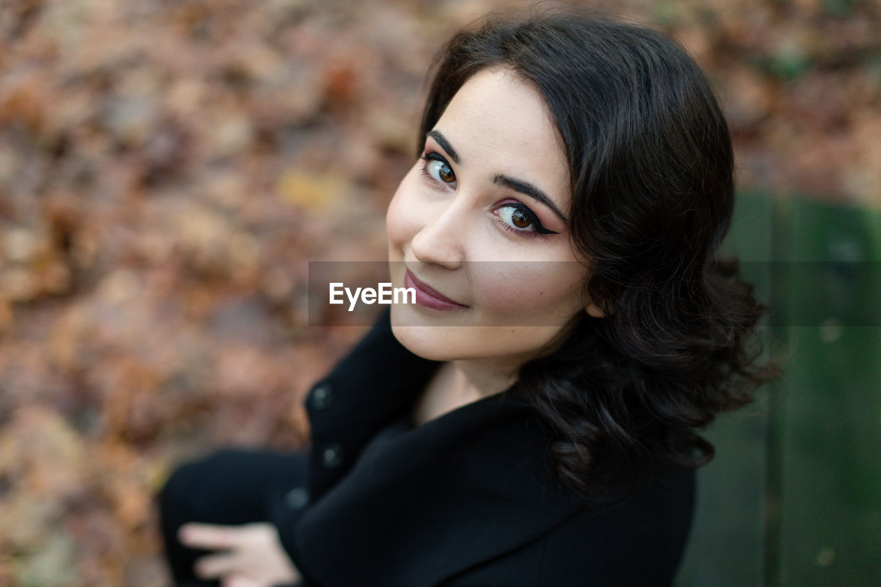 Close-up portrait of young woman sitting outdoors