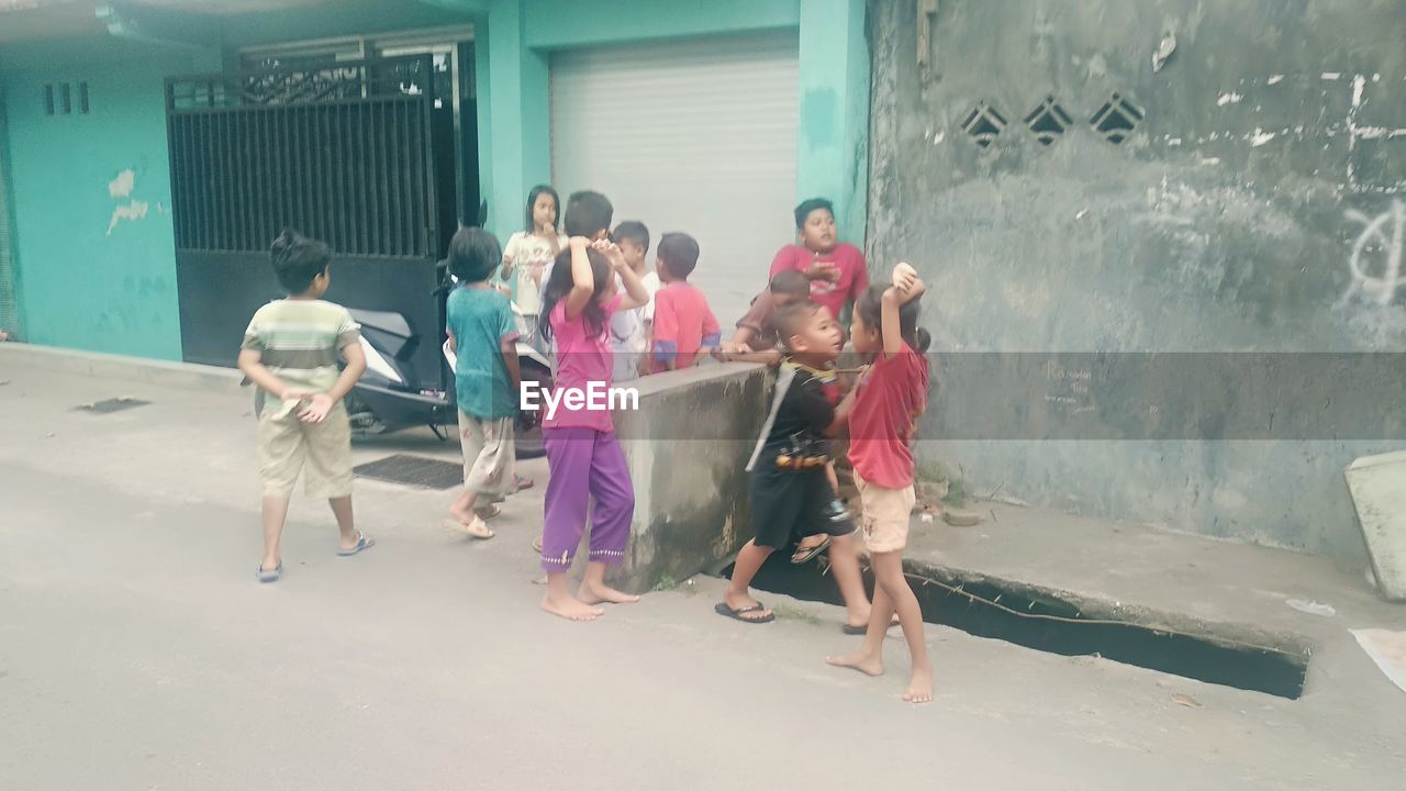 REAR VIEW OF PEOPLE WALKING IN FRONT OF AN ANIMAL