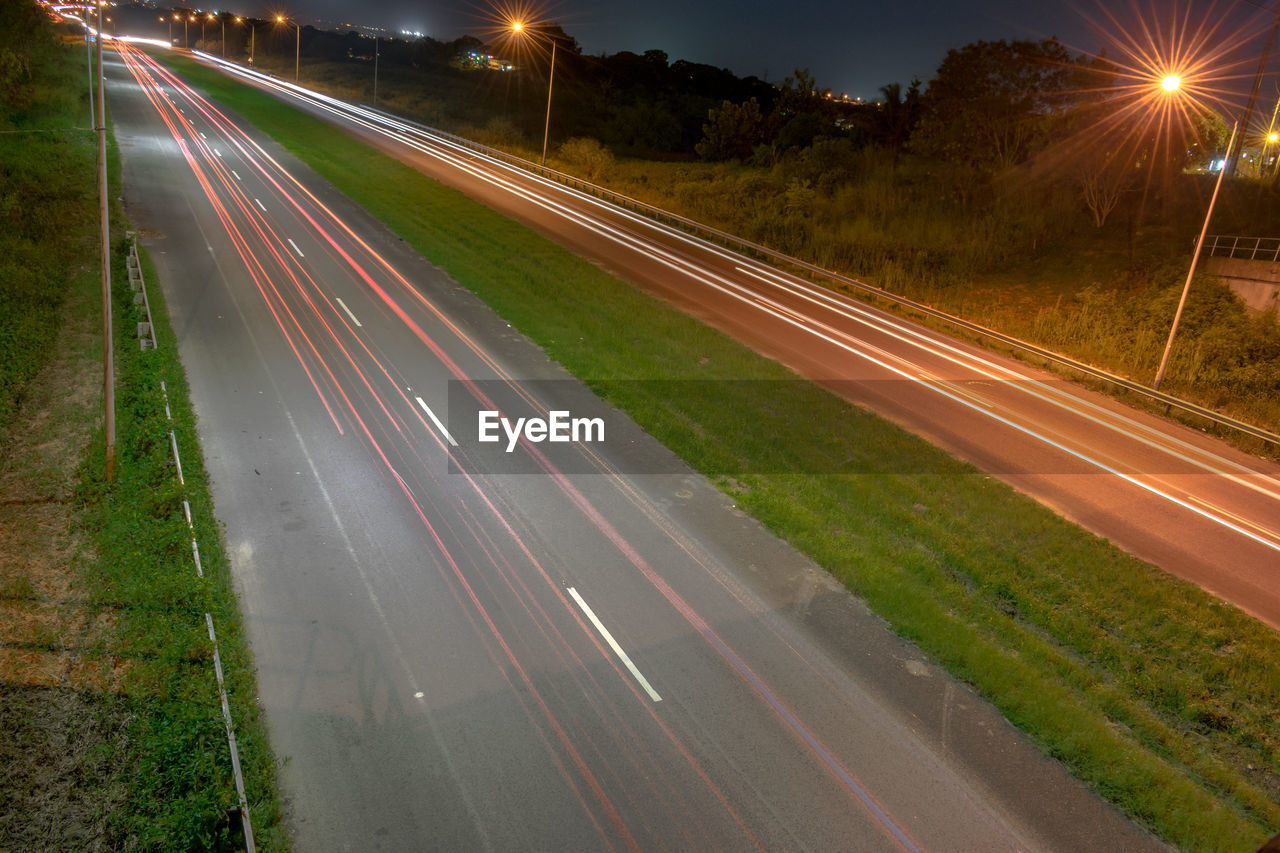 BLURRED MOTION OF LIGHT TRAILS ON STREET AT NIGHT