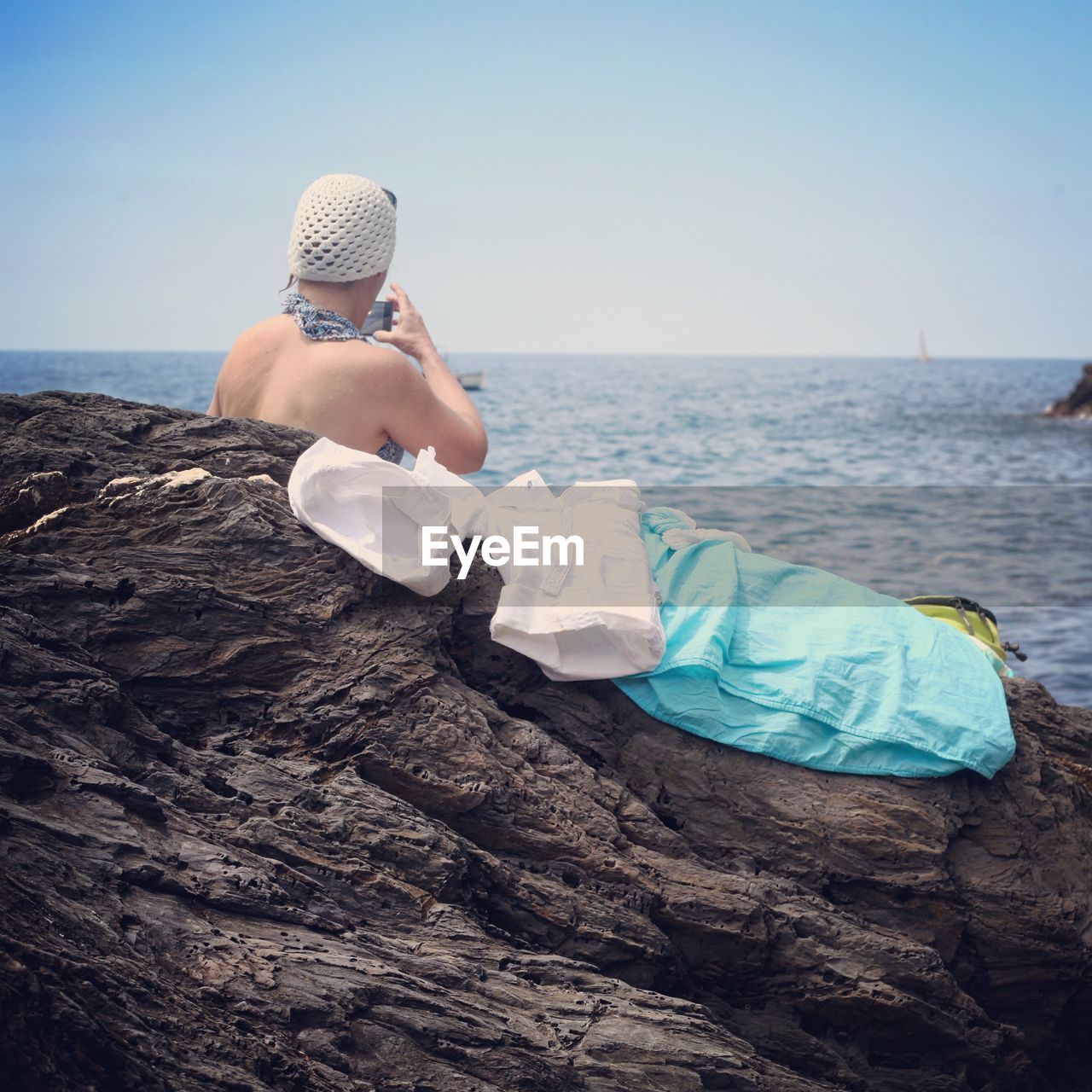 Rear view of woman overlooking calm blue sea