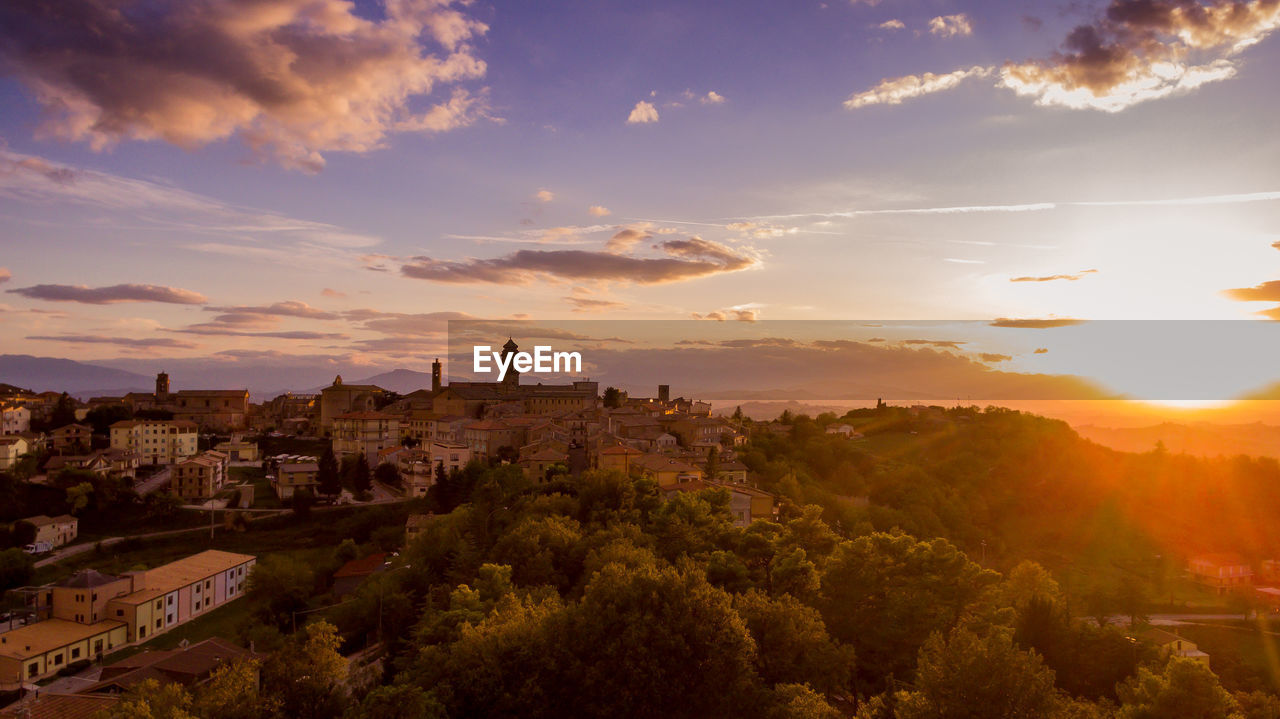 HIGH ANGLE VIEW OF BUILDINGS AGAINST SKY DURING SUNSET